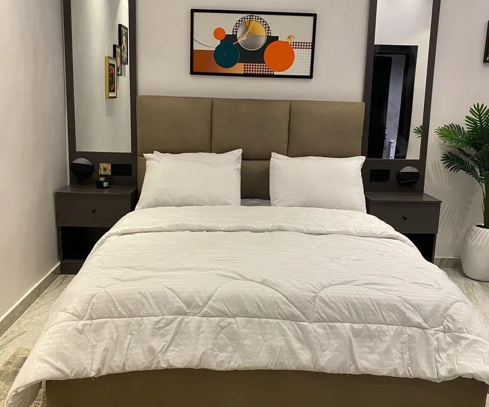Bedroom with made bed and window light